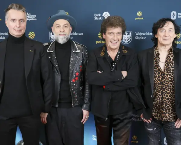 Czterech mężczyzn, w tym legendy polskie zespoły muzyczne lat 70-80, pozuje na ściance.
