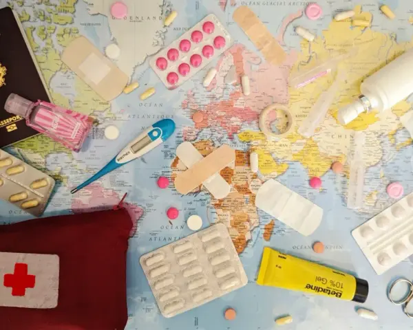 Une trousse de secours prête pour un voyage autour du monde : passeport, pansements, thermomètre, pilules, désinfectant et crème.