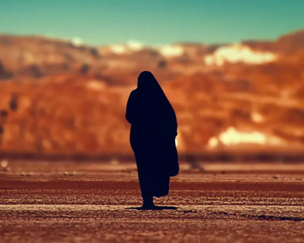 Eine Silhouette einer Person, die in der Wüste steht, erinnert an Johannes 1, wo das Wort am Anfang war.