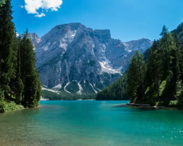 Lago di Braies, perla del tour Trentino, con montagne imponenti e acque cristalline.