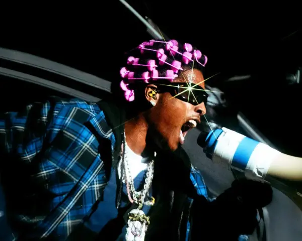 ASAP Rocky z różowymi wałkami na głowie i megafonem zapowiada swój nowy album.