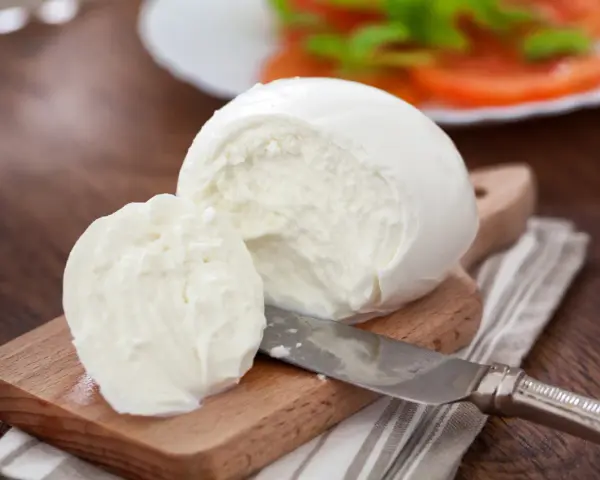 Świeża mozzarella na desce, gotowa do sałatki. Czy mozzarella jest wegetariańska? Tak, tradycyjnie tak!