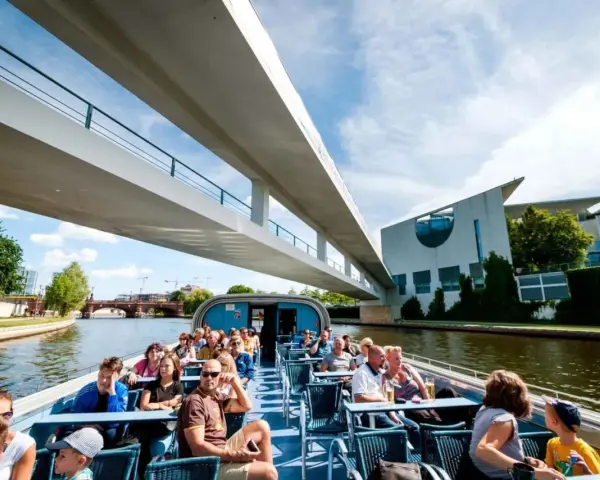 Bootsfahrt auf der Spree in Berlin unter einer modernen Brücke mit Blick auf das Regierungsviertel.