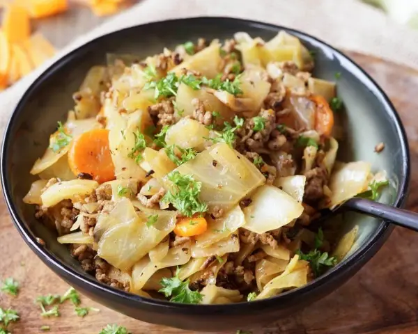 Herzhaftes Spitzkohlgericht mit Hackfleisch und Karotten, garniert mit frischer Petersilie. Ein deftiges Essen, das gut schmeckt.