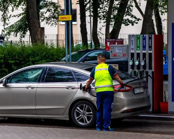 Pracownik stacji paliw tankuje samochód. Rosnące ceny paliwa to problem, który dotyka każdego kierowcę.