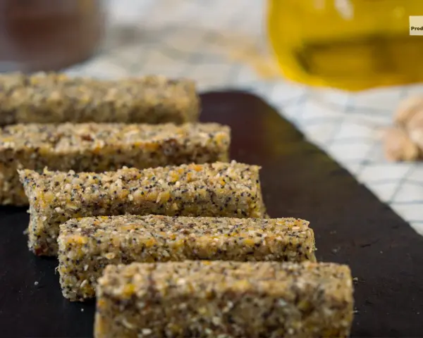 Barritas energéticas caseras de cereales y semillas en una tabla de pizarra.