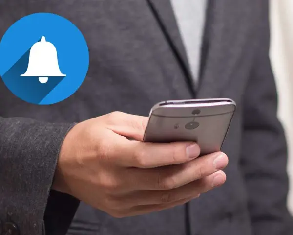 En person håller en smartphone med en notiscenter-ikon för iPhone.
