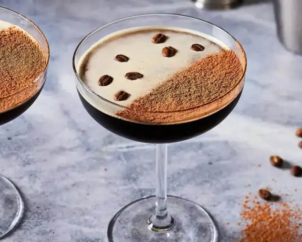 Dwa eleganckie koktajle z pianką, posypane kakao i ziarnami kawy. Idealne do picia z Baileys, gdy masz ochotę na coś słodkiego.