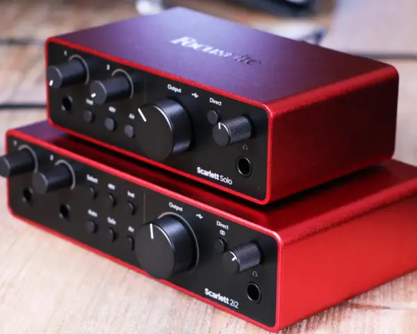 Dwa czerwone interfejsy audio Focusrite Scarlett Solo 3gen i Scarlett 2i2 ułożone jeden na drugim.