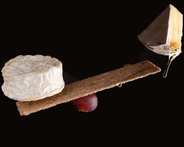 Queso camembert y brie, con galleta y uva. La diferencia entre camembert y brie se aprecia en sus formas y texturas.