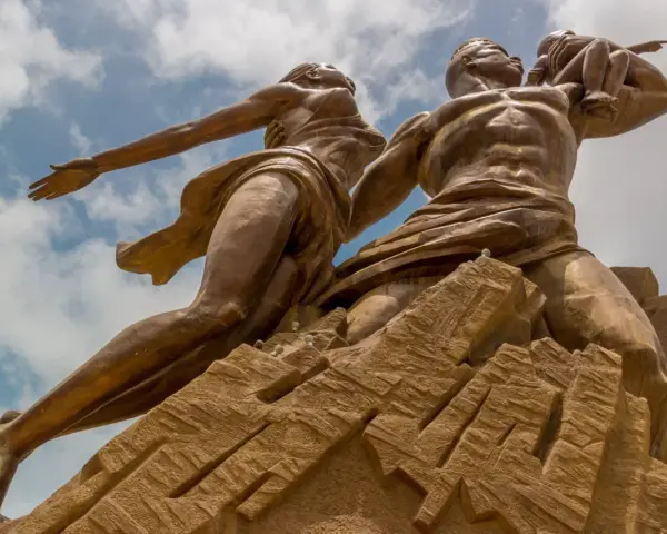 Pomnik Odrodzenia w Senegalu, symbolizujący dumę i przyszłość. Monumentalna rzeźba na tle błękitnego nieba.