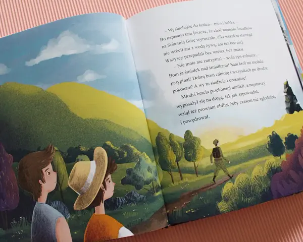 Dwóch chłopców patrzy na krajobraz, gdzie samotny podróżnik idzie ścieżką. To ilustracja z baśni o Sobotniej Górze.