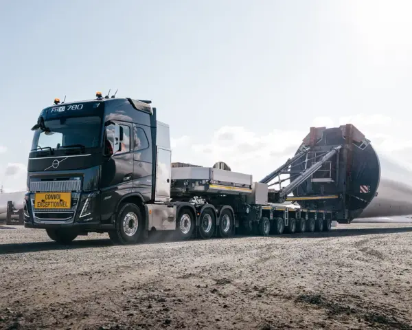 Potężny Volvo FH16 transportuje ogromną łopatę turbiny wiatrowej.