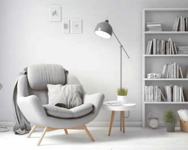 Un sillón cómodo junto a una estantería llena de libros, creando una acogedora biblioteca en casa.