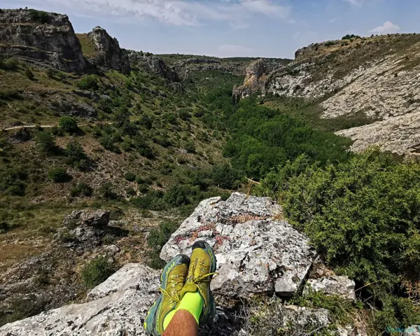 Botas de trail running sobre roca, contemplando el cañón del río Dulce en Guadalajara.
