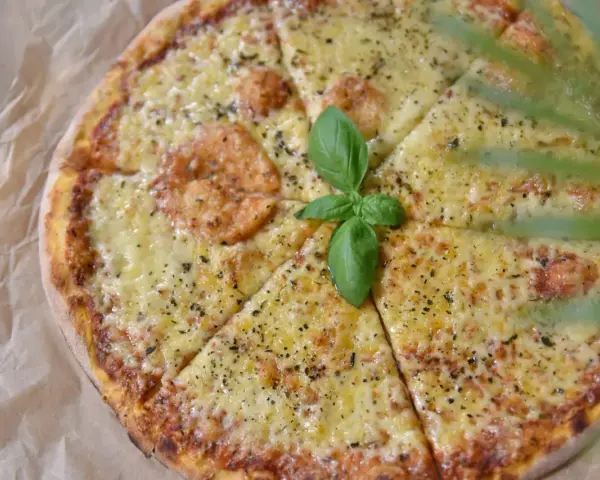 Pyszna pizza z serem i bazylią, idealne dodatki do pizzy.