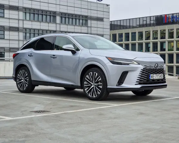 Eleganckie japońskie auta, jak ten srebrny Lexus, prezentują się nowocześnie na tle biurowców.