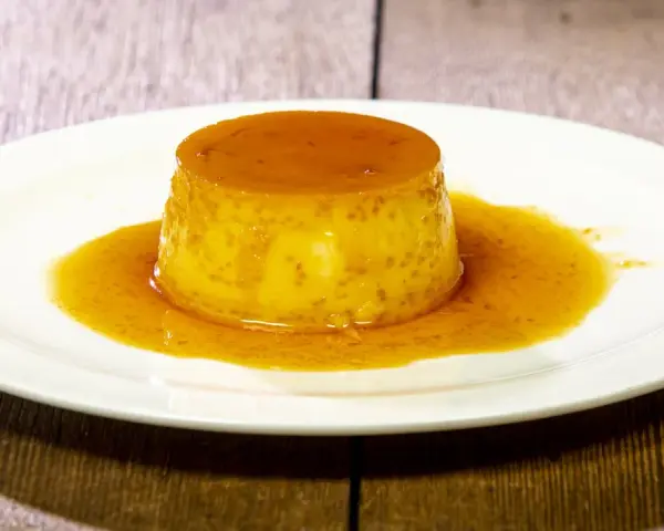 Un delizioso dolce al cucchiaio, un flan dorato con sciroppo di caramello, che ricorda il sapore del dulce de leche.
