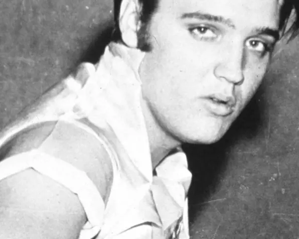 Junger Elvis Presley, mit seinem charakteristischen Blick und jugendlichem Charme, blickt in die Kamera.