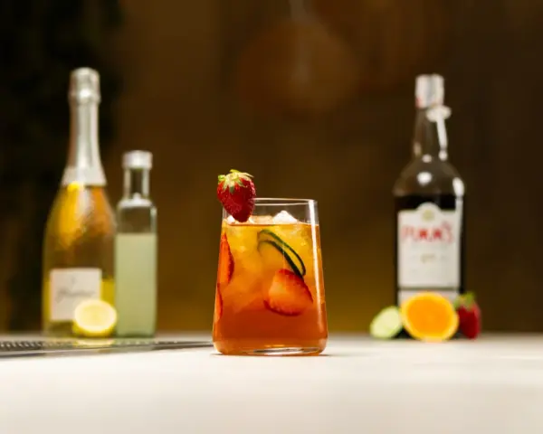 Orzeźwiający drink z Pimm's No. 1, truskawkami i ogórkiem, w kontraście do Aperol Spritz.