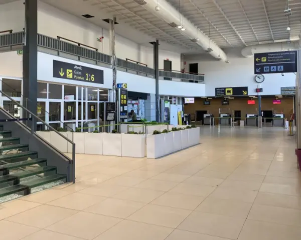 Inside an airport terminal, signs point to boarding gates 1-6. This is likely the closest airport to San Sebastian.