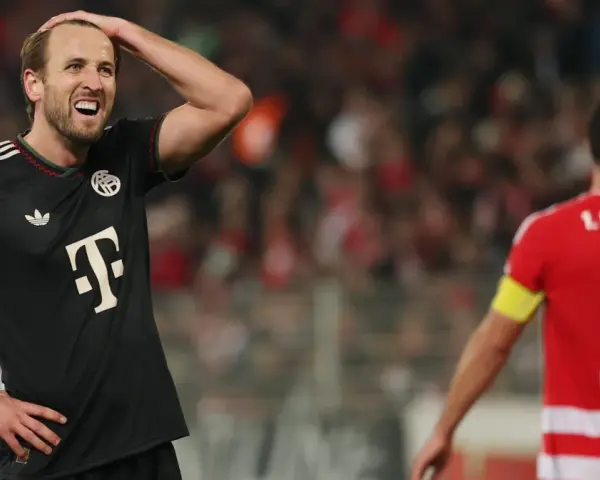 Piłkarz Bayernu w czarnej koszulce z T na piersi, z ręką na głowie, w meczu przeciwko Union Berlin.