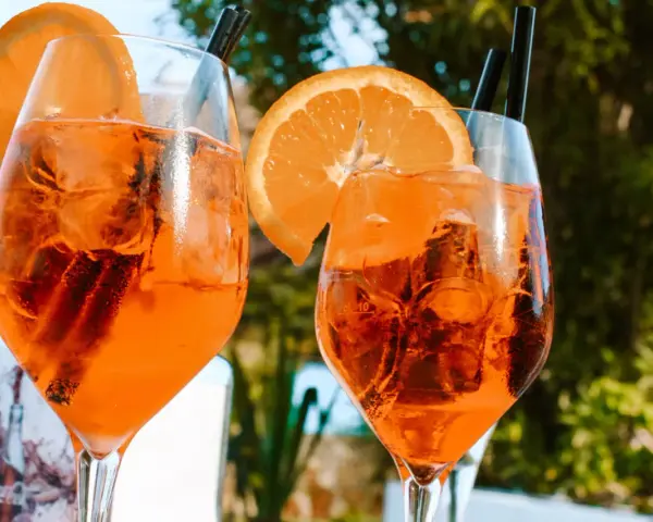 Dwa orzeźwiające drinki z pomarańczą i lodem, idealne na włoskie aperitivo.