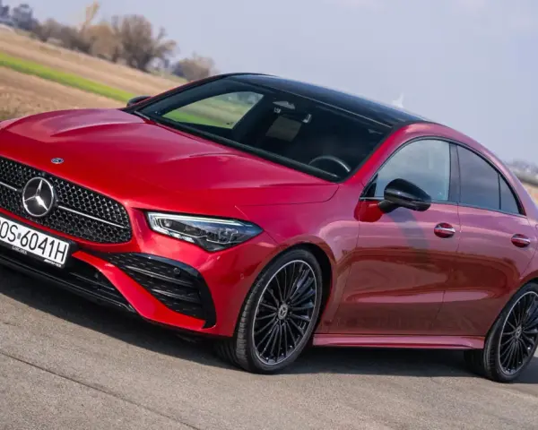 Czerwony Mercedes CLA na drodze, z widocznymi detalami, które mogą sugerować potencjalne mercedes cla awarie i problemy.