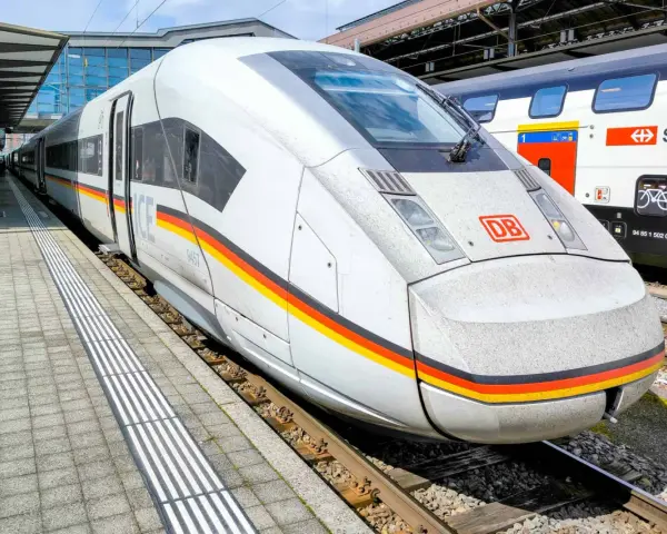 ICE train with German flag colors at a station, ready for a journey between Germany and Switzerland.