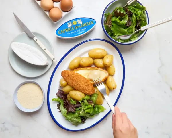 Délicieuse recette Caprice des Dieux pané, servi avec des pommes de terre et une salade verte. Le fromage coulant est irrésistible !