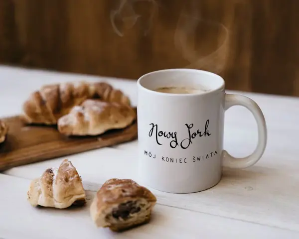 Kawa i croissanty, idealne na śniadanie. Kubek z napisem "Nowy Jork, mój koniec świata" to świetny pomysł, co kupić w USA do Polski.