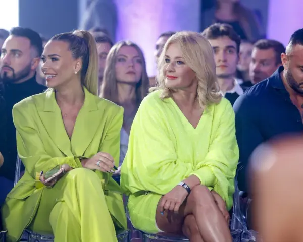 Dwie kobiety w stylizacjach w kolorze limonkowym siedzą w pierwszym rzędzie.
