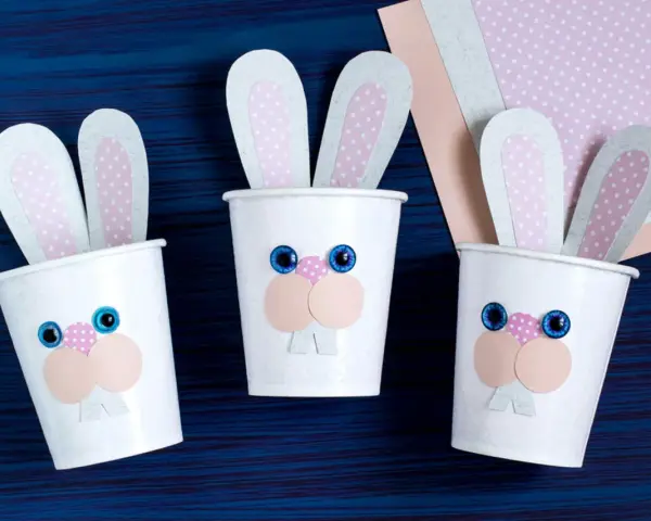 Drei süße Osterhasen-Becher, perfekt für Ostern basteln mit Kleinkindern. Bunte Ohren und lustige Gesichter machen sie zum Hingucker.