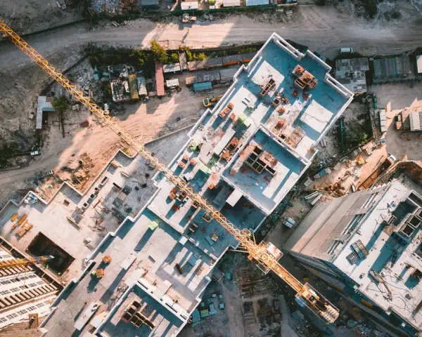 Aerial view of a construction site, showcasing the efficiency of drones in construction by providing an overhead perspective of building progress and material placement.