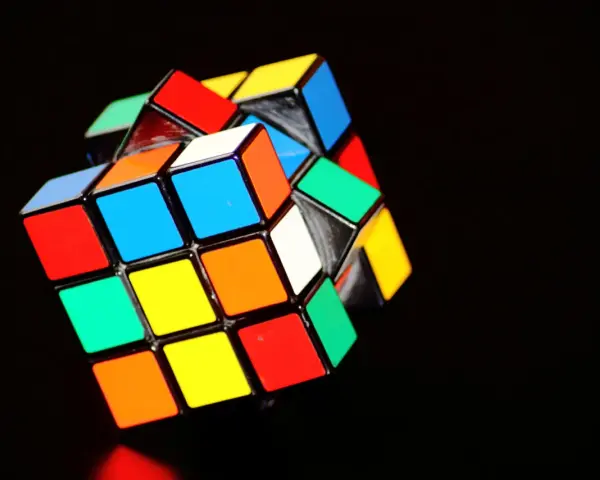 En färgglad rubiks kub 3x3 ligger på en mörk bakgrund.
