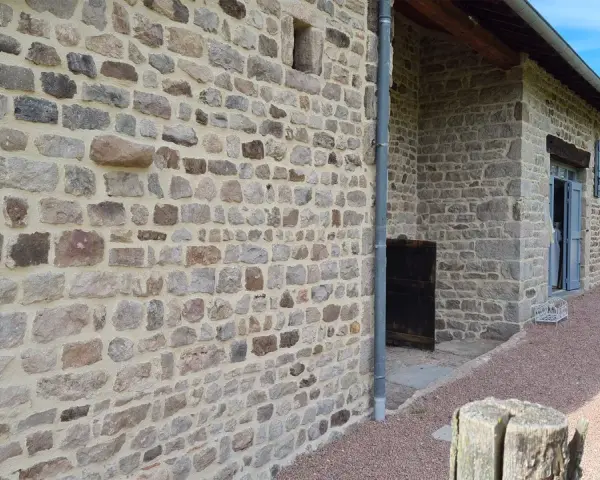 Mur en pierre avec un mortier de couleur joint clair, typique d'une rénovation de bâtisse ancienne.