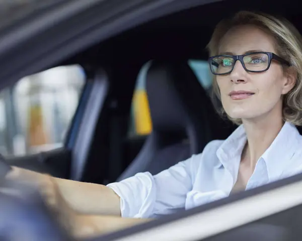 Frau mit Brille fährt Auto. Ohne Brille fahren ohne Brille Strafe.