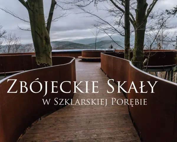 Złoty widok ze ścieżki w koronach drzew w Szklarskiej Porębie. Drewniana kładka z rdzawo-brązowymi balustradami wije się wśród drzew, prowadząc do punktu widokowego.
