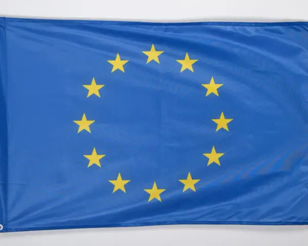 Flaga Unii Europejskiej, symbol jedności i współpracy, z dwunastoma złotymi gwiazdami na niebieskim tle.