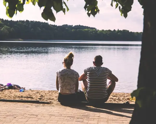 Para, siedząca na plaży, patrzy na jezioro. Czy to idealny partner dla byka?