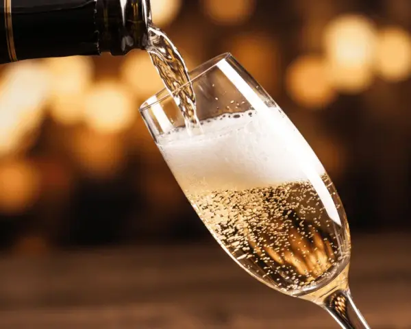 Bąbelki musującego prosecco wypełniają kieliszek, gdy jest nalewane z butelki. To jest właśnie to, co to jest prosecco – włoskie wino musujące.