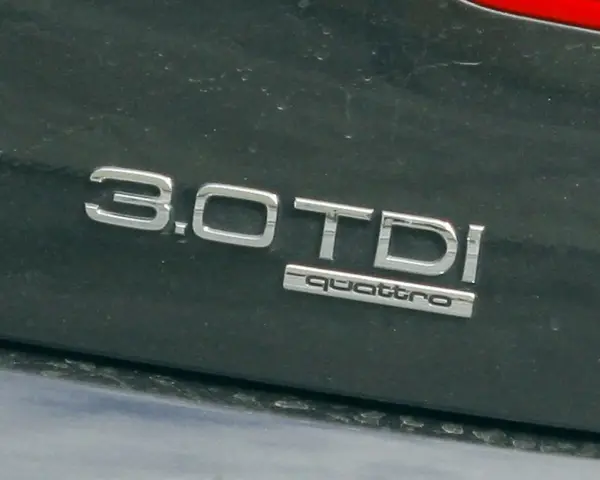 Napis "3.0 TDI quattro" na ciemnym lakierze. Ta pojemność silnika sugeruje moc i osiągi.