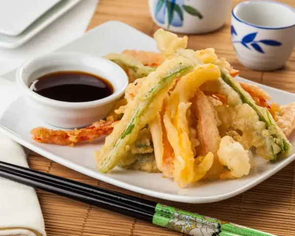 Crujiente tempura de verduras, con zanahoria, calabacín y pimiento, servida con salsa de soja.