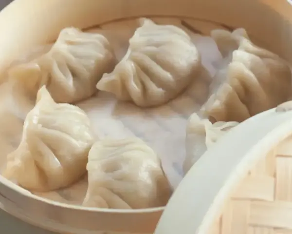 Gorące, parujące pierożki chińskie w bambusowym parowniku. Delikatne ciasto i soczyste nadzienie kuszą smakiem.