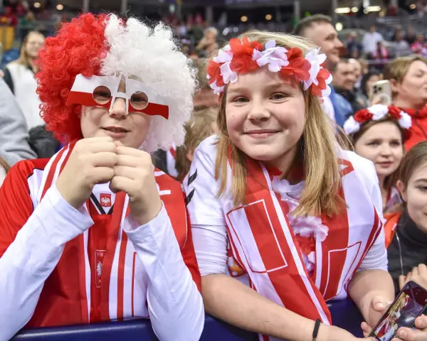 Dzieci kibicują w barwach narodowych podczas meczu pierwszej ligi piłki ręcznej.
