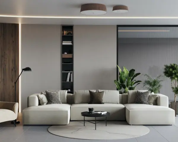 Un ampio divano modulare, perfetto per un soggiorno open space, con poltrona, libreria e piante.