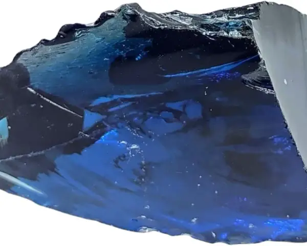 Fragmento de obsidiana azul con reflejos profundos y texturas irregulares, como un trozo de cielo nocturno solidificado.