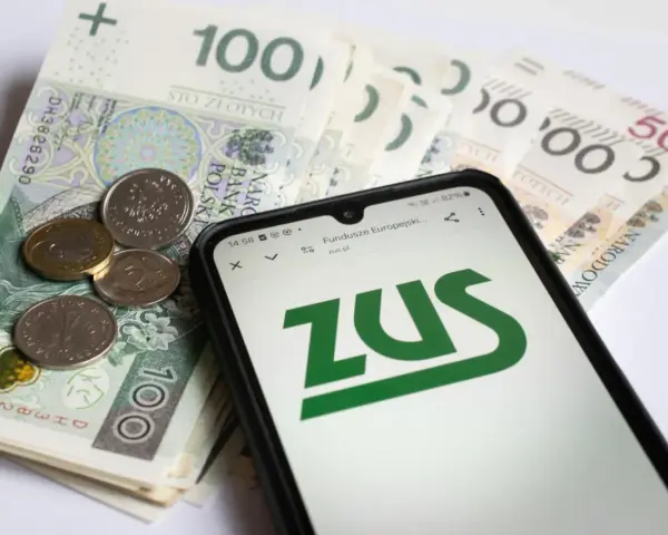 Złotówki i monety obok telefonu z logo ZUS. Sprawdzamy, czy renta wdowia 2026 będzie dostępna.