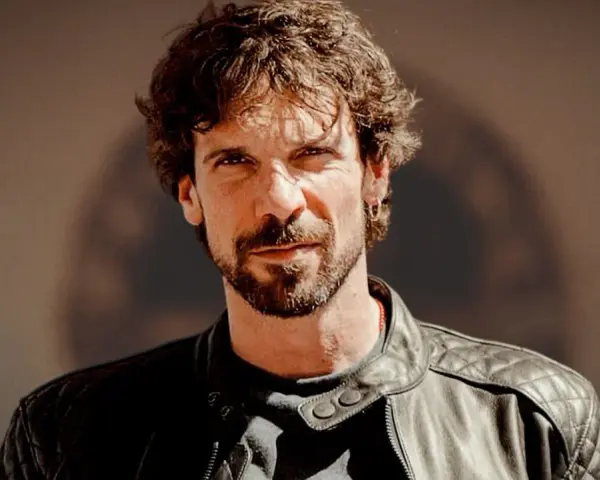 Ritratto di Francesco Montanari, attore noto per i suoi ruoli in film e programmi TV. Indossa una giacca di pelle.