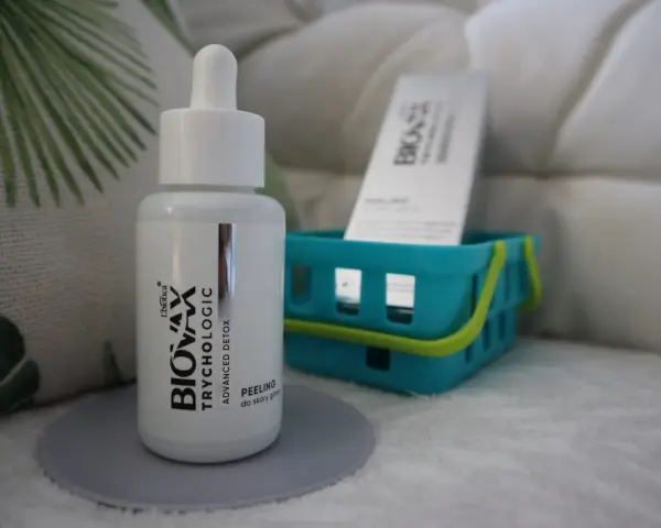 Buteleczka peelingu do skóry głowy L'biotica Bio-Vax Trychologic Advanced Detox stoi na szarej podkładce.